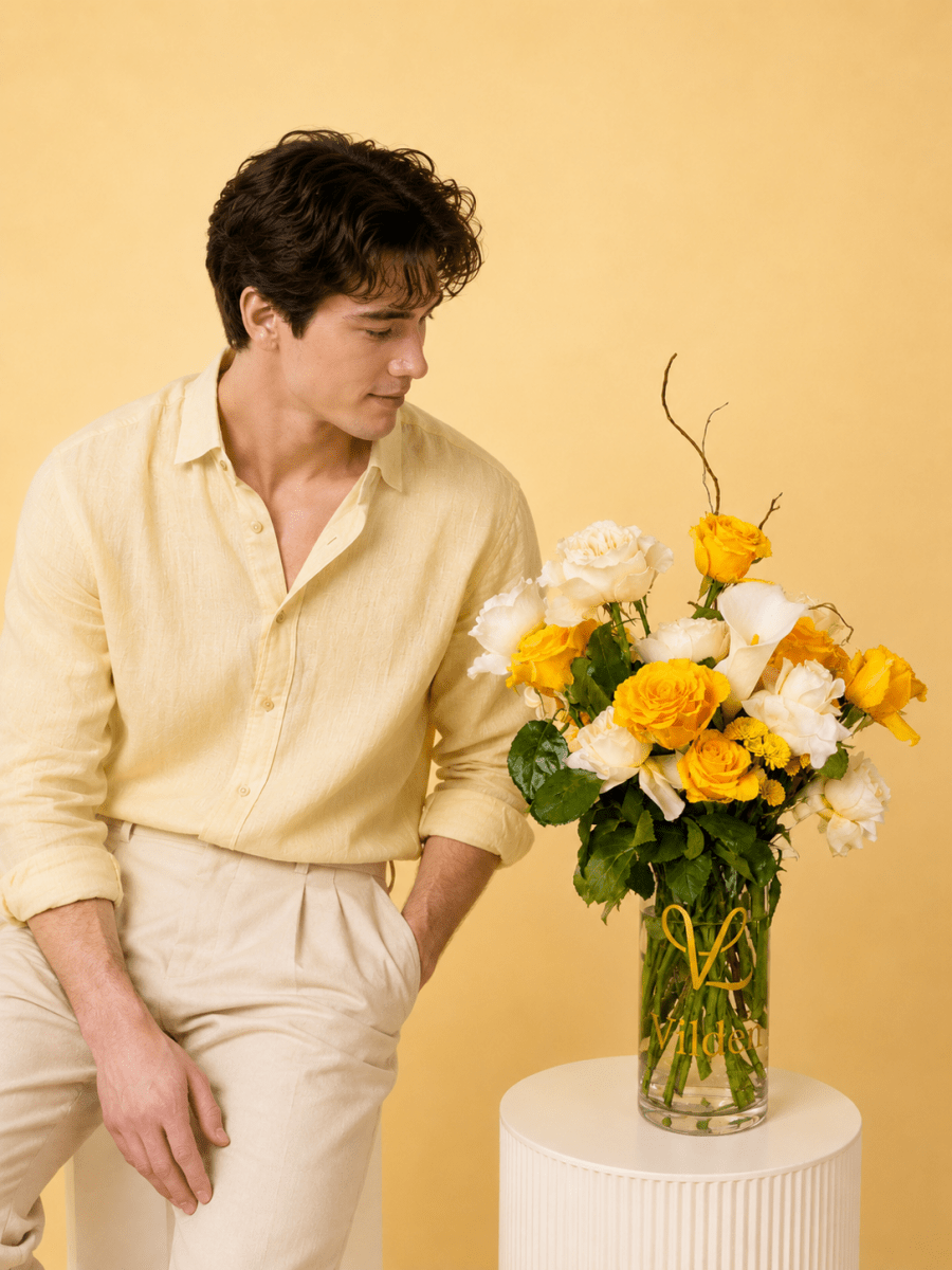 Lemon and creamy roses with a dash of soft pink carination vase arrangement with a model at Vilden studio