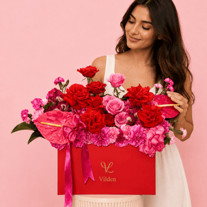 Amore Vivace red and pink rose floral arrangement in a Vilden box with a model at the Vilden Studio
