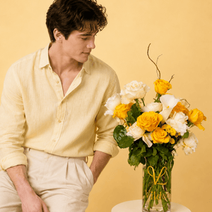 Lemon and creamy roses with a dash of soft pink carination vase arrangement with a model at Vilden studio