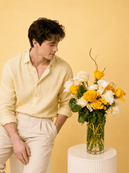 Lemon and creamy roses with a dash of soft pink carination vase arrangement with a model at Vilden studio