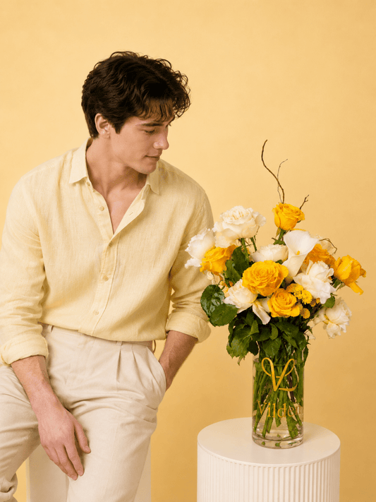 Lemon and creamy roses with a dash of soft pink carination vase arrangement with a model at Vilden studio