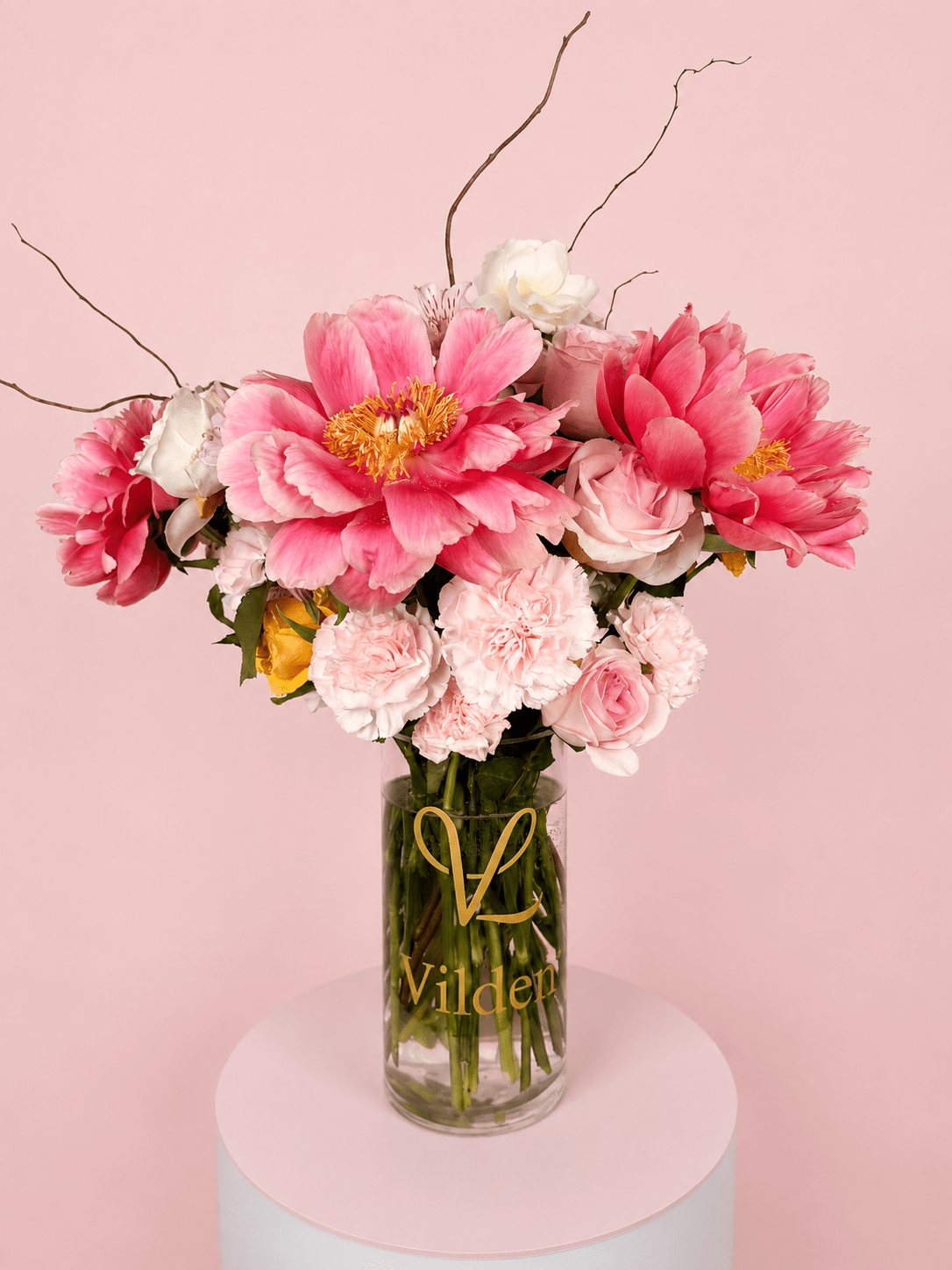 Peony Muse Vase Arrangement with pink peonies, soft roses, carnations, and delicate floral accents in a clear Vilden vase.