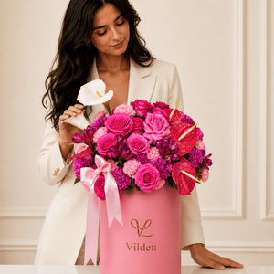 Pink Rhapsody floral arrangement in a Vilden box with a model in a cream blazer