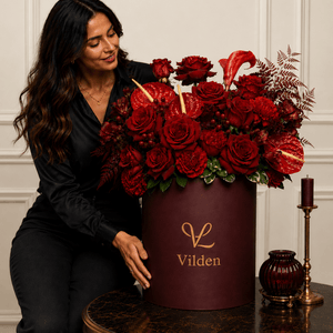 Velvet Ember red roses in a burgundy and red handpicked blooms in a Vilden flower box with a female model.