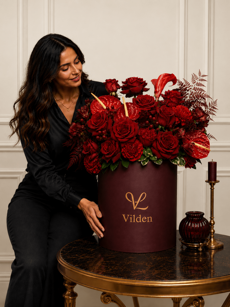 Velvet Ember red roses in a burgundy and red handpicked blooms in a Vilden flower box with a female model.