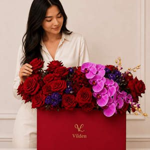 Ruby Orchid red rose and pink orchid arrangement in a Vilden box with a natural-looking model