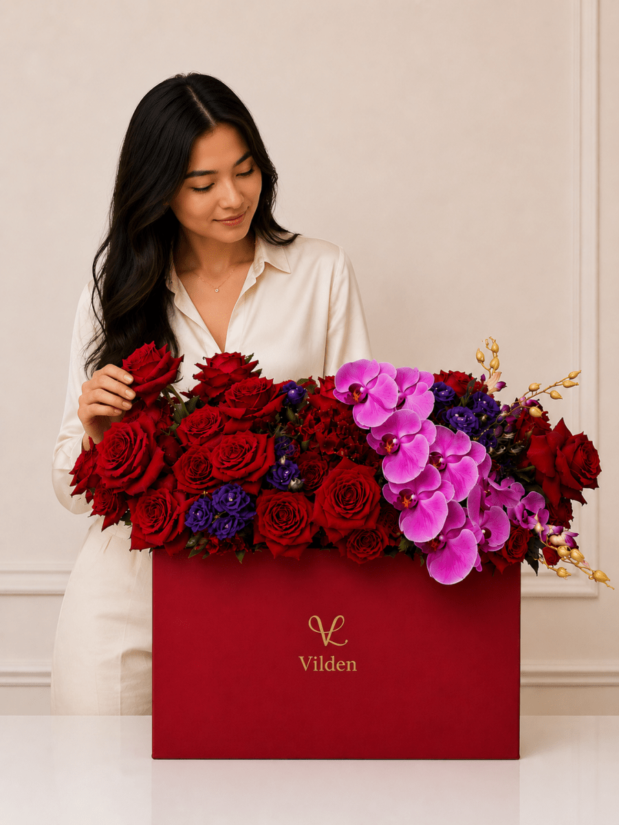 Ruby Orchid red rose and pink orchid arrangement in a Vilden box with a natural-looking model