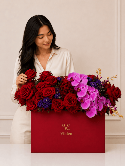 Ruby Orchid red rose and pink orchid arrangement in a Vilden box with a natural-looking model