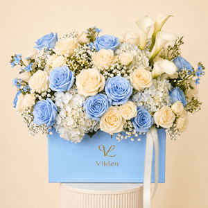 Elegant Serenade in Blue bouquet exudes tranquility with soft blue roses, cream hydrangea, and delicate baby's breath.