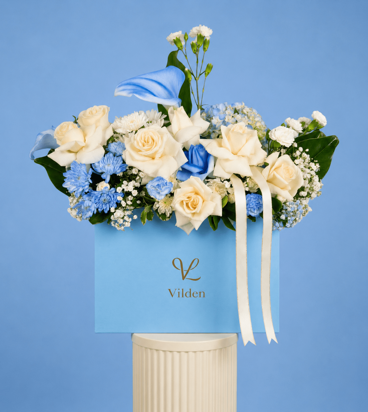 Tranquil Blue arrangement exudes serenity and calm with soft cream roses, delicate blue blooms, and a graceful calla lily.