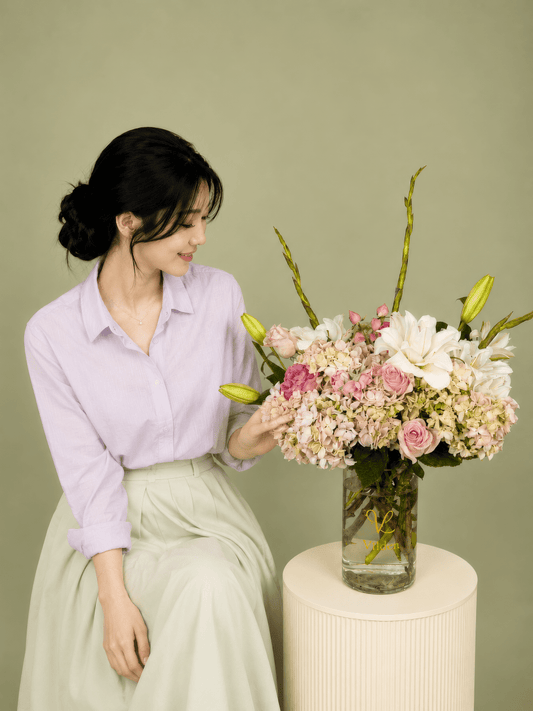 White creamy hydrangeas, white lilies, soft pink spray roses, and pink roses with a model at Vilden studio.