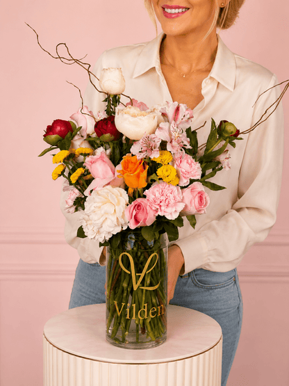 Garden Sonata featuring pink, white, and yellow blooms. It is perfect for special and memorable occasions.